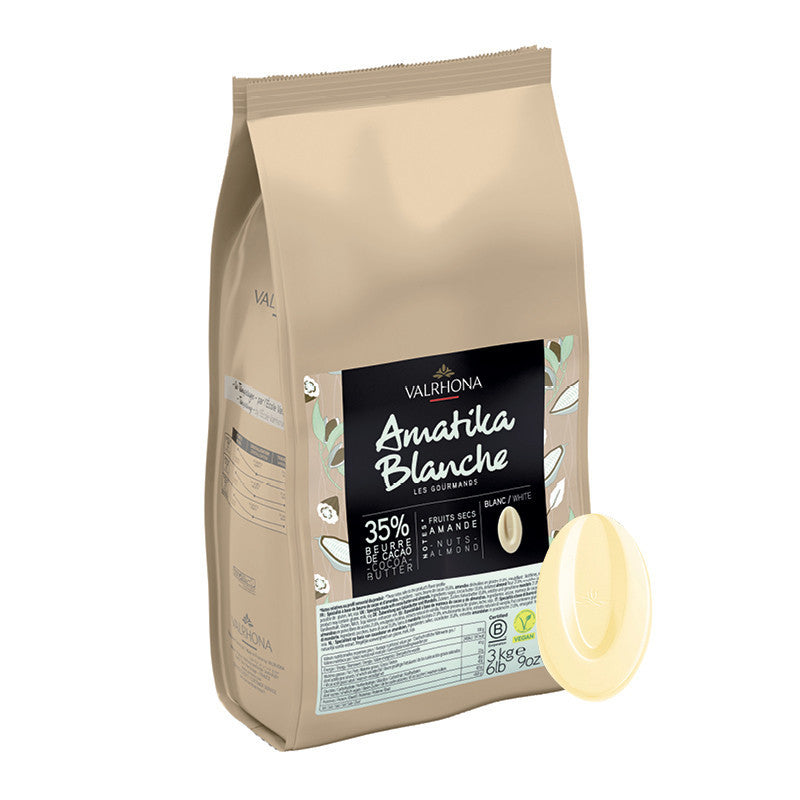 Beige Valrhona Amatila Blanche chocolate bag with a white chocolate piece on a white background
